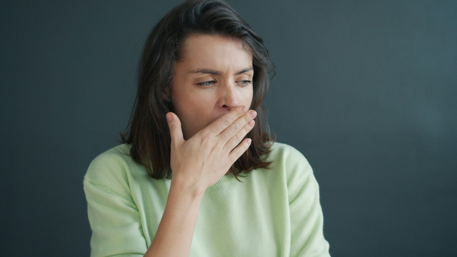 Woman yawning at her desk, exhausted from perimenopause fatigue
